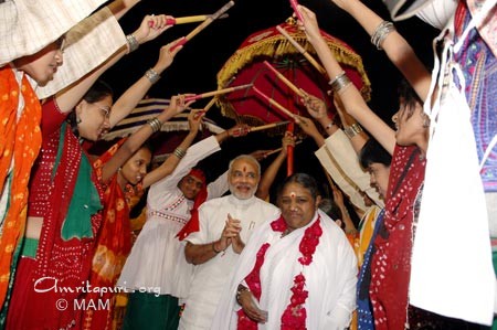 Dandiya dancers formed an archway for Amma